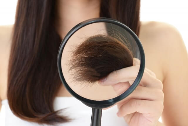 髪の毛をチェックする女性
